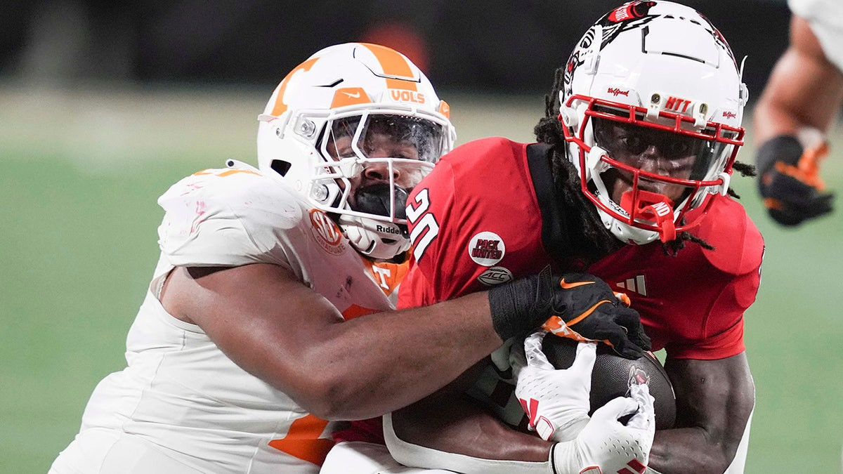 Tennessee player shoves fan storming field to the ground after upset loss to Arkansas  at george magazine