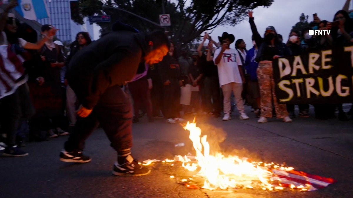 Anti-ICE protesters in Los Angeles spit on and burn American flag  at george magazine