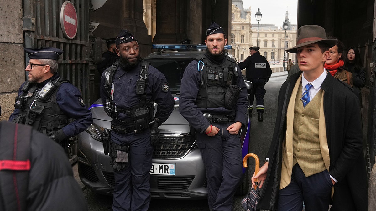 Mystery man in dapper suit goes viral after appearing in Louvre heist investigation photo  at george magazine