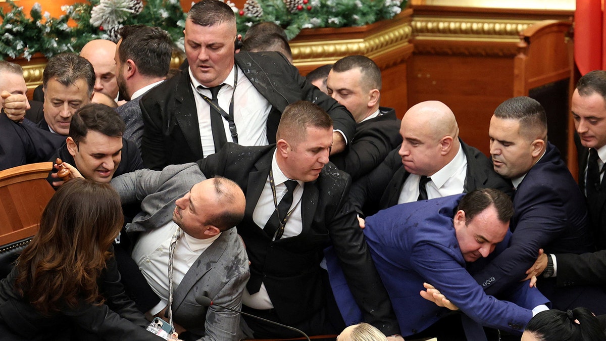 Albanian opposition lawmakers light flares, scuffle with police amid parliament chaos over corruption probe at george magazine