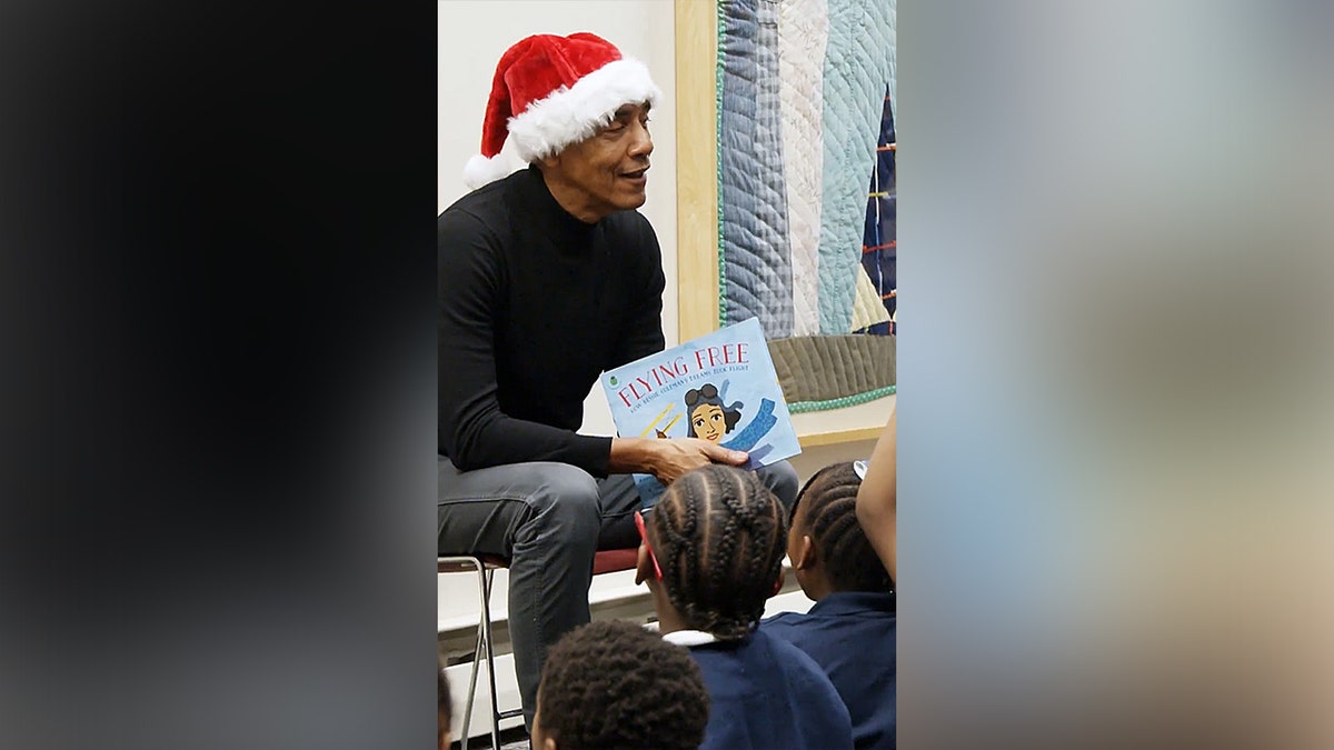 Obama surprises Chicago students in Santa hat for holiday library story time reading session at george magazine