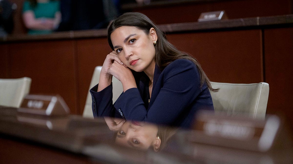 Rep. Alexandria Ocasio-Cortez, D-N.Y., rests her head in her hands