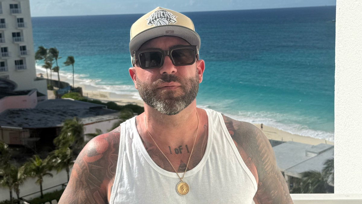 chris scali poses for photo on balcony of bahamas hotel