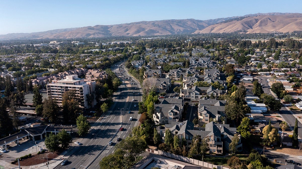 Aerial view of Fremont, California with homes, mountains and highways.