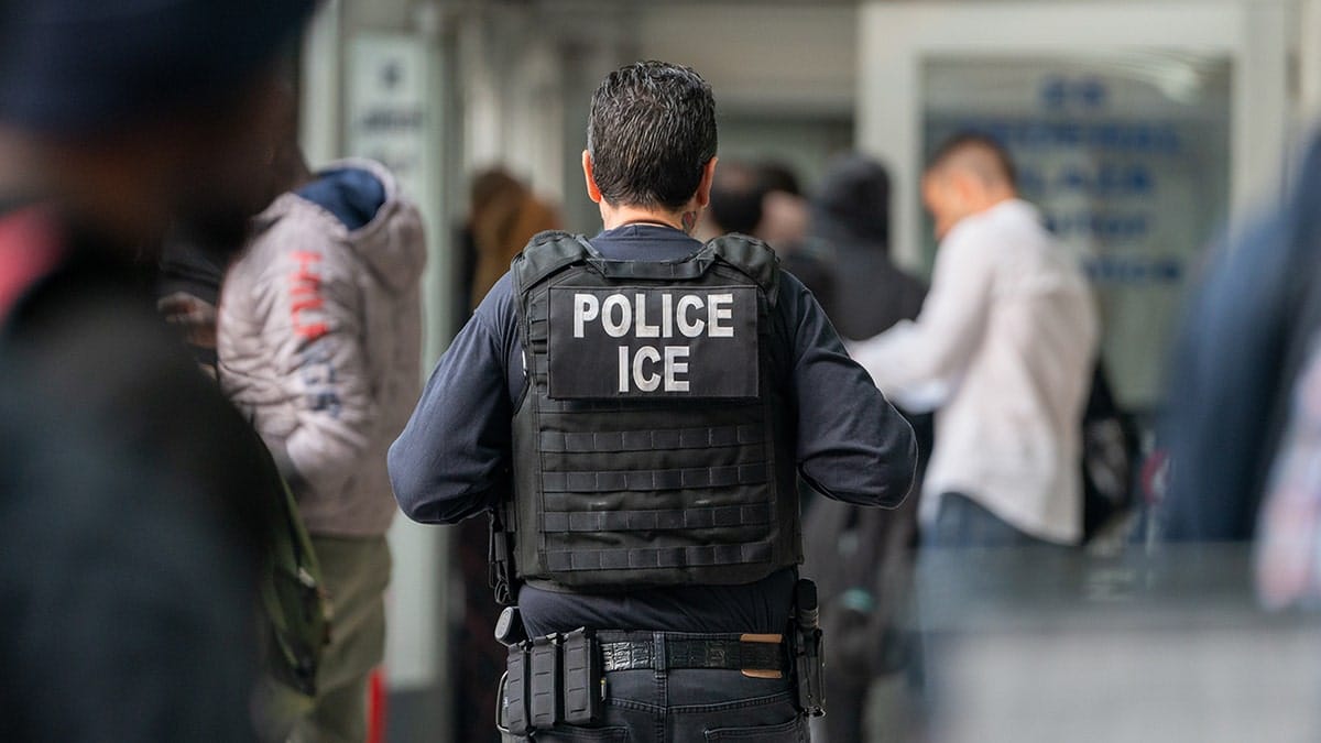 An ICE agent monitoring hundreds of asylum seekers inside a federal building.