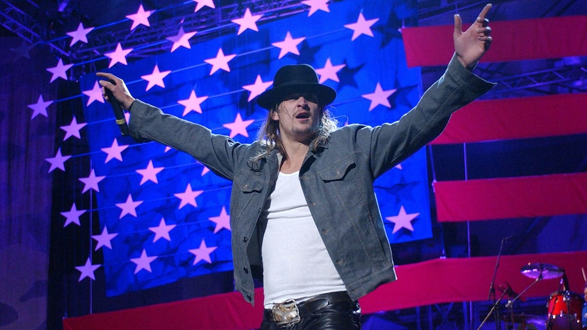 Kid Rock performs in front of an American flag
