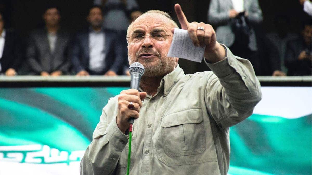 Iranian Parliament Speaker Mohammad Bagher Qalibaf speaks into a microphone and gestures during an event.