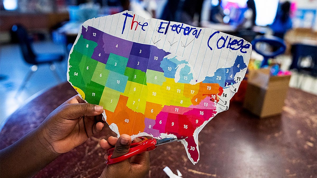 A 4th grader working on an election themed art project at a school desk.
