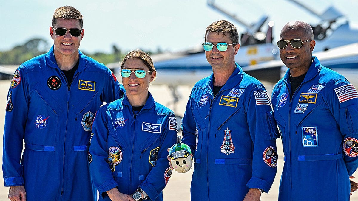 Astronauts Jeremy Hansen, Christina Koch, Reid Wiseman, and Victor Glover standing during a welcome ceremony at Kennedy Space Center