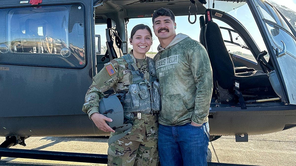 Emma and Jacob Rodriguez in front of a US Army Black Hawk helicopter