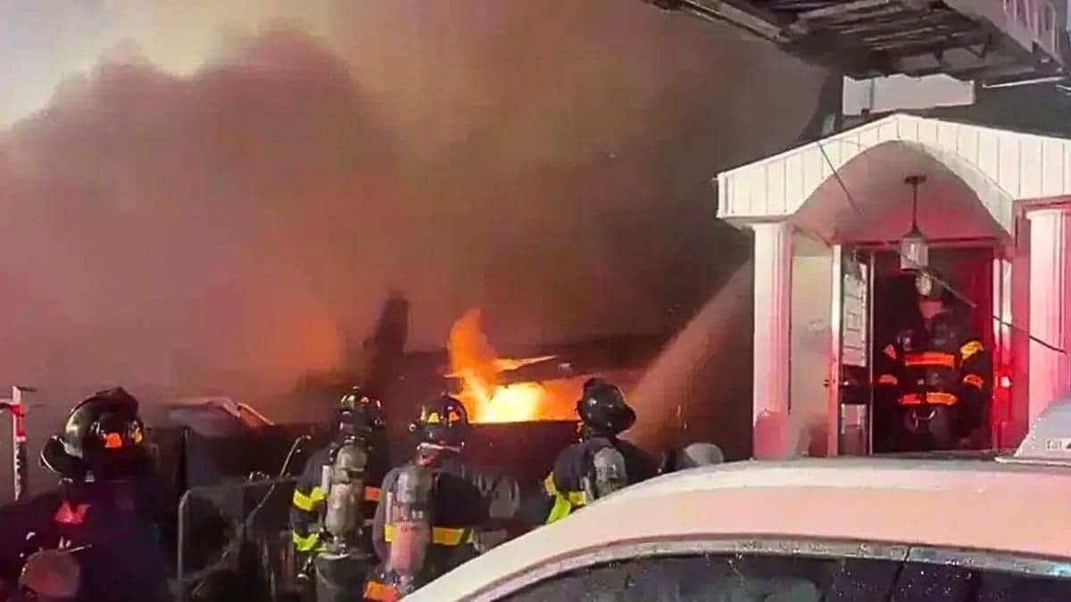 Firefighters spray water on a large home fire