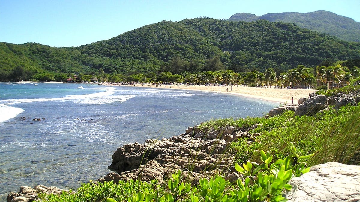 View of beach in Haiti with people walking on sand