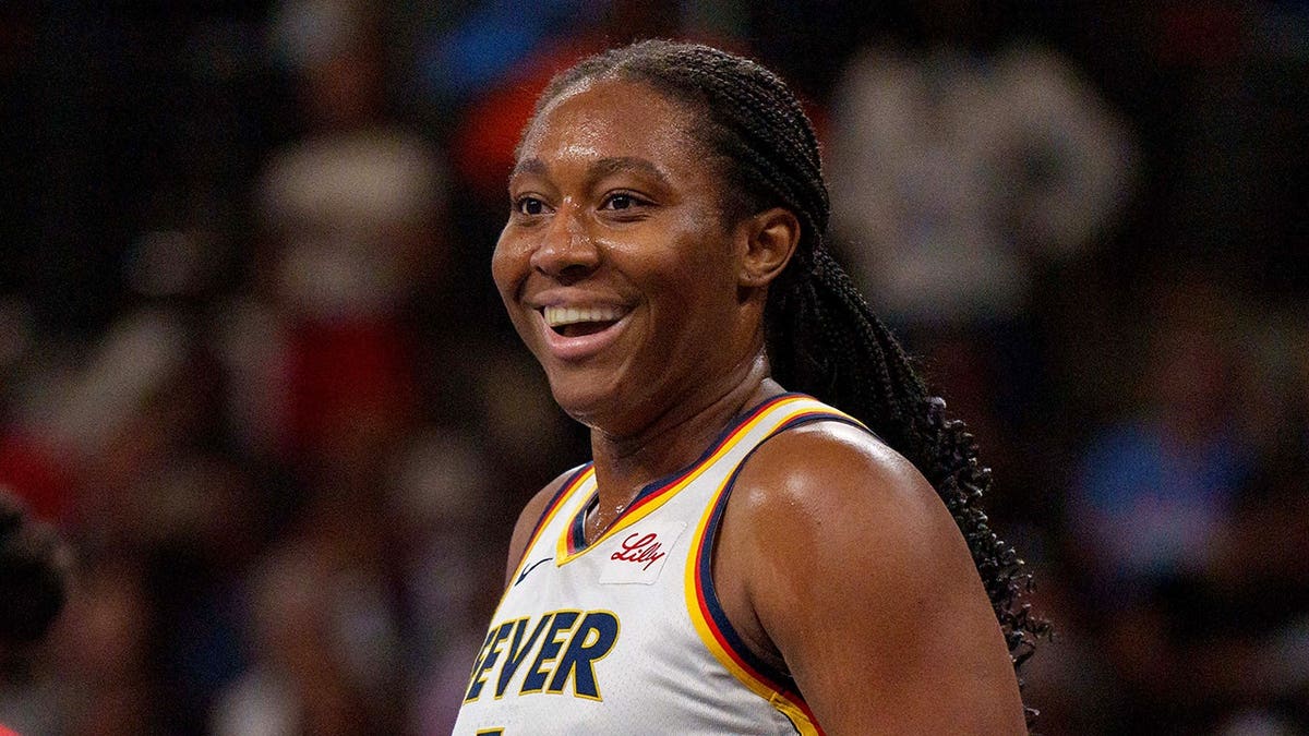 Aliyah Boston smiling on the basketball court during a WNBA playoff game