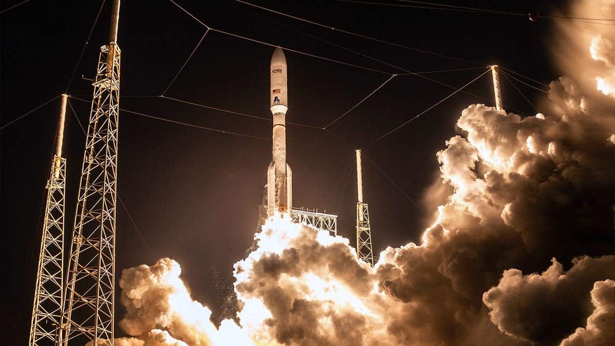 A rocket launches with plumes of smoke billowing from it.