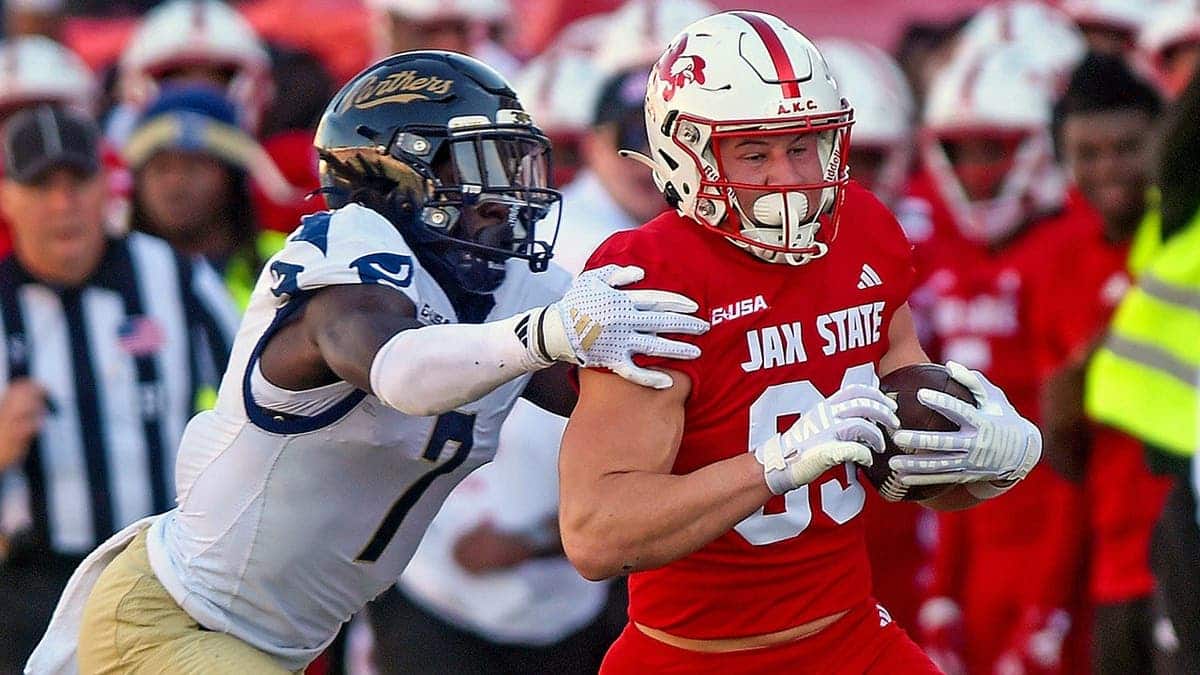 Jacksonville State's Brock Rechsteiner running with football evading FIU's Jamal Potts at AmFirst Stadium