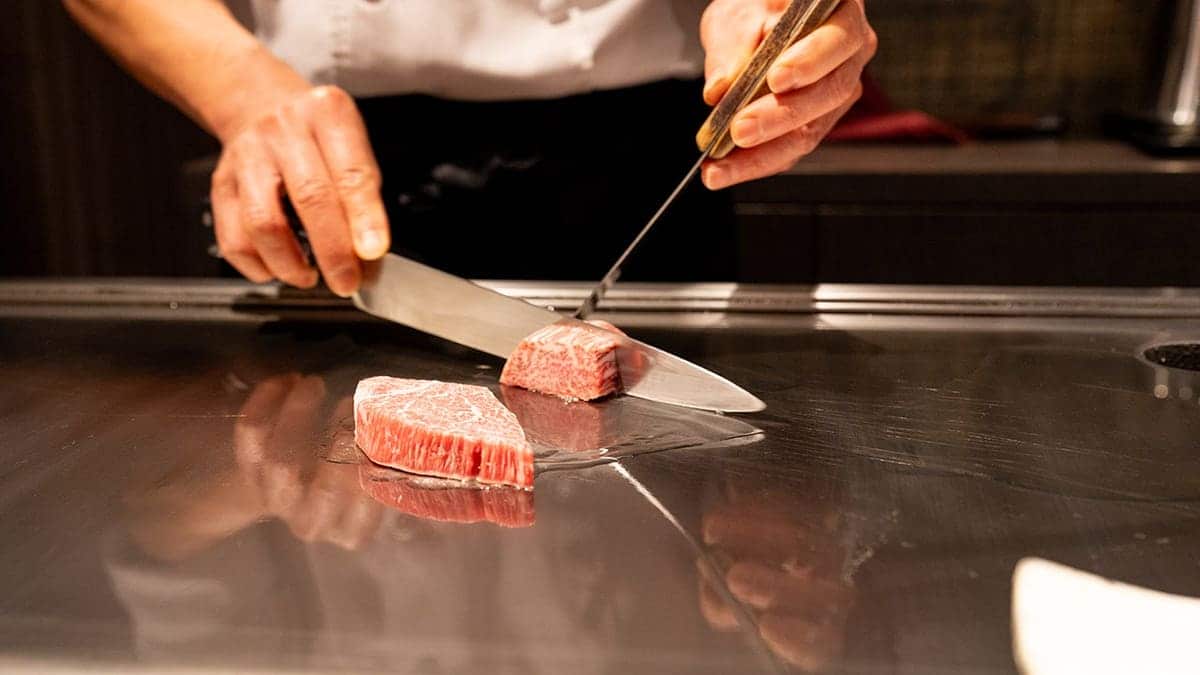 Chef slicing Kobe beef on a hotplate