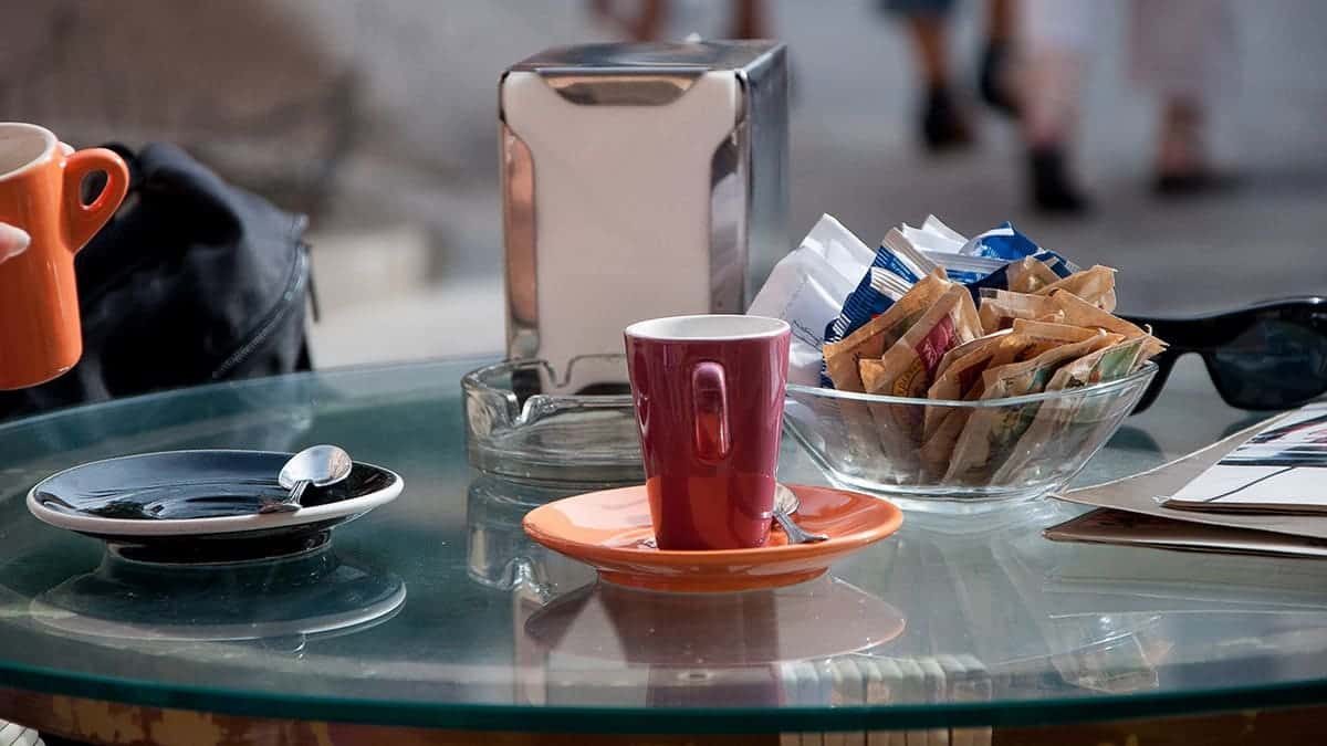 Coffee cup with sugar packets on a table
