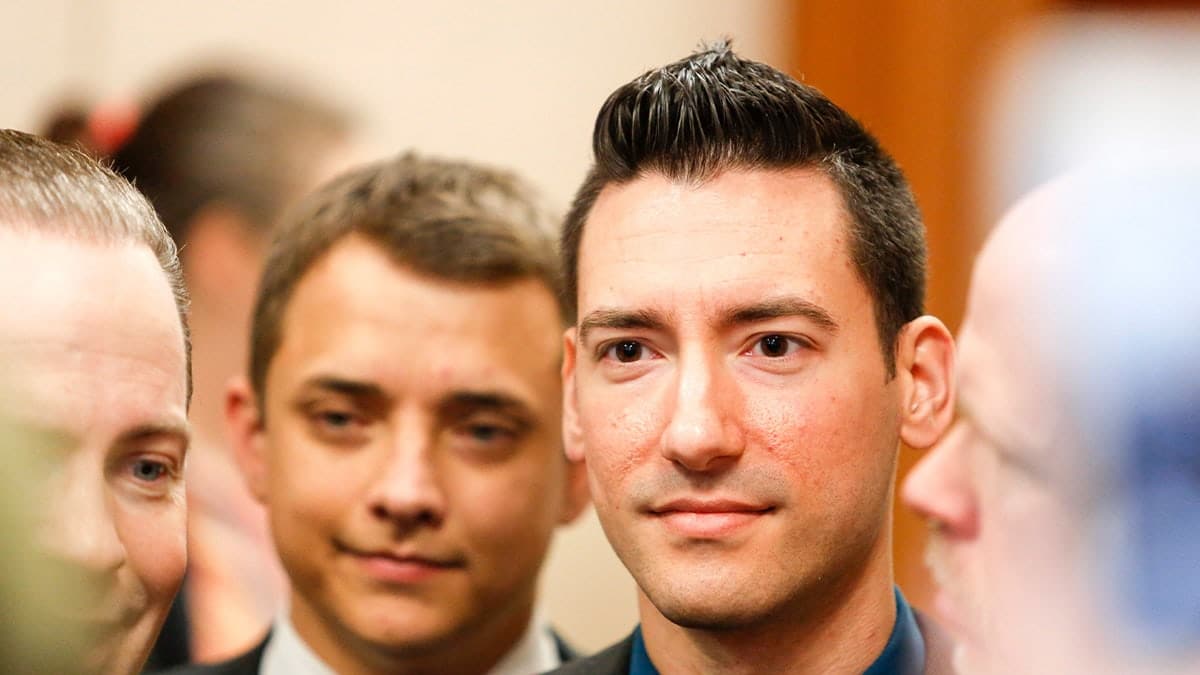 David Daleiden standing in a courtroom and smiling.