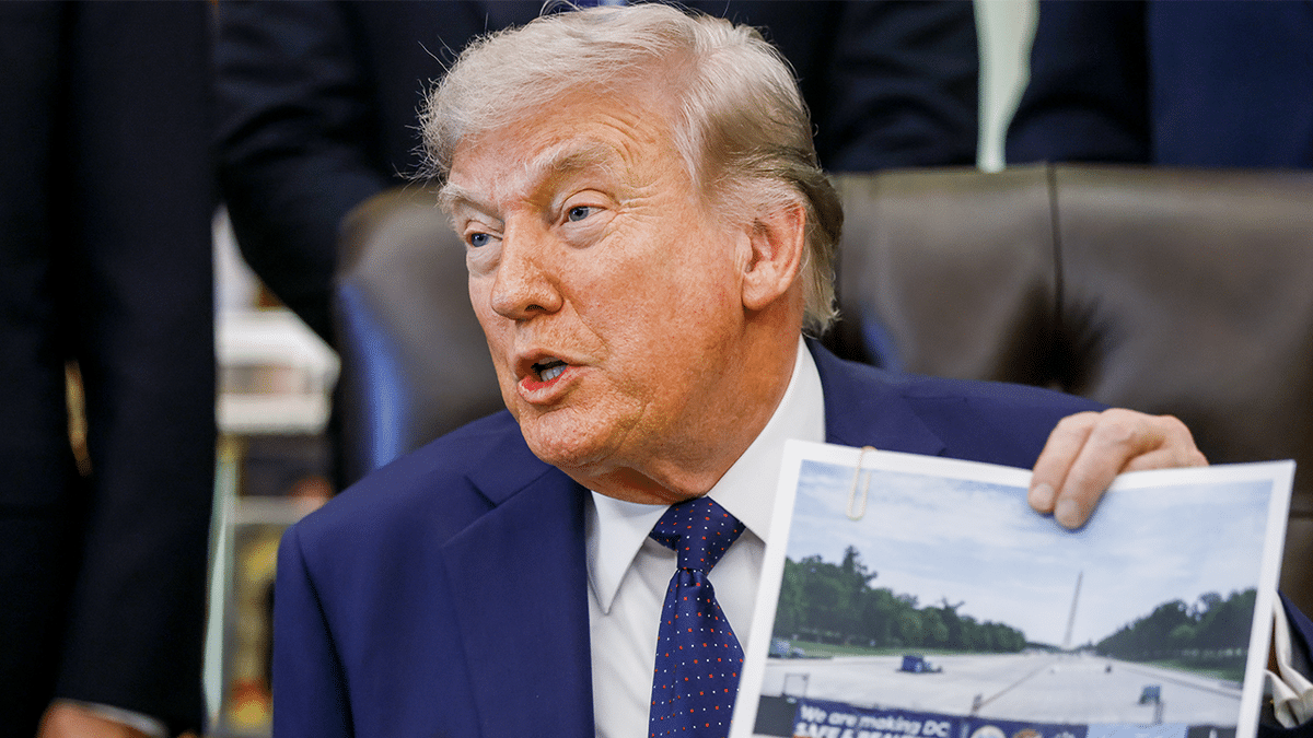 Trump holding up a photo of the progress on the National Mall's reflecting pool