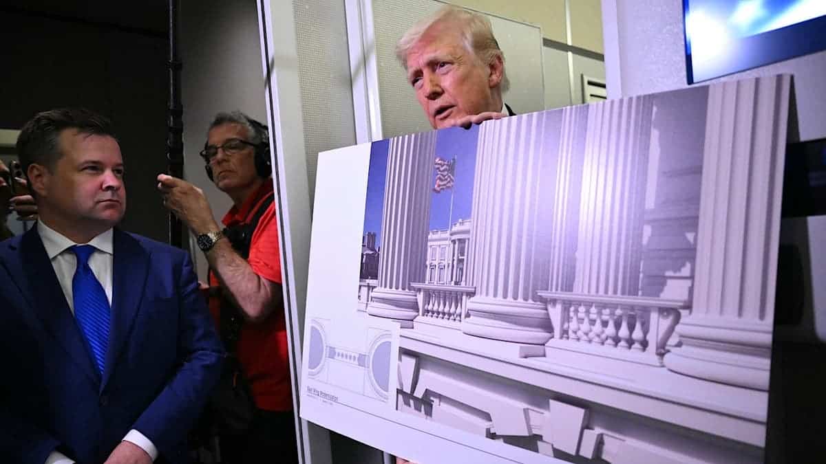President Donald Trump holding a rendering while speaking to reporters aboard Air Force One
