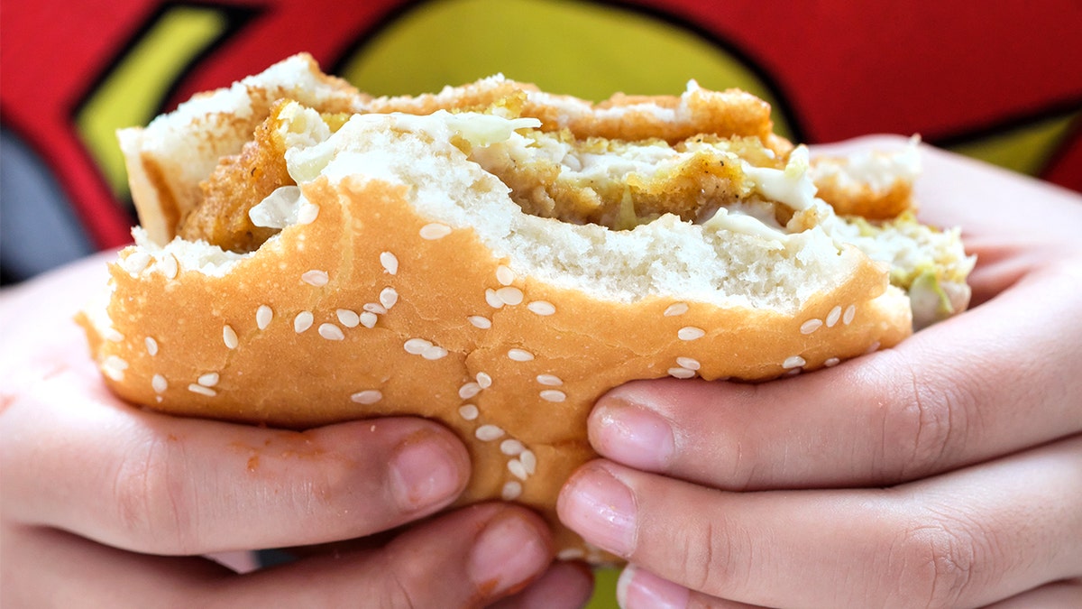 Man eating a fish sandwich at a fast-food restaurant