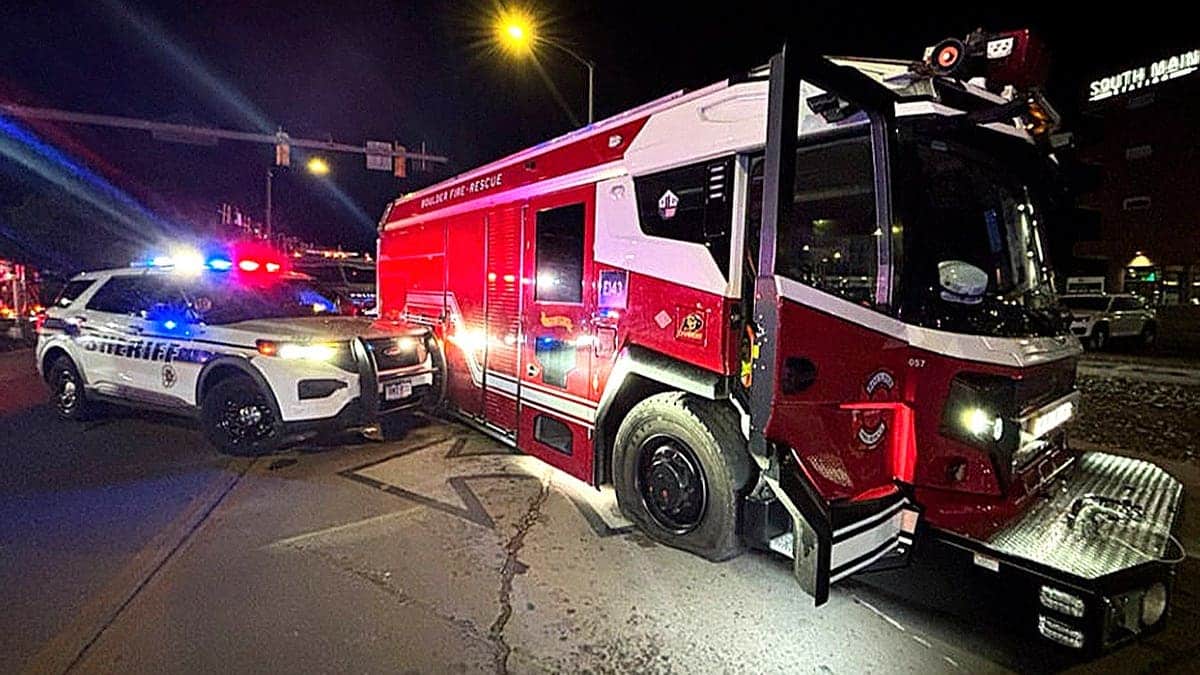 sheriff's car flashing lights next to fire truck at night