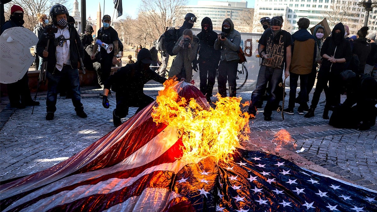 Members of Communist Party USA burning an American flag on Colorado State Capitol steps