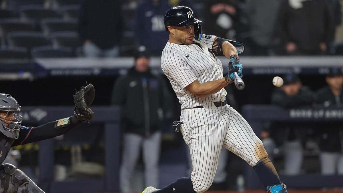 New York Yankees designated hitter Giancarlo Stanton hitting a single during a baseball game.