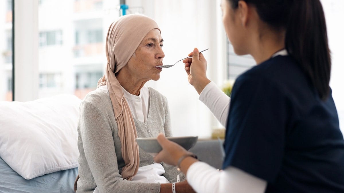 Woman getting fed by nurse