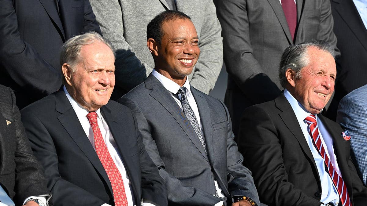 Jack Nicklaus, Tiger Woods and Gary Player standing together at St Andrews Old Course.