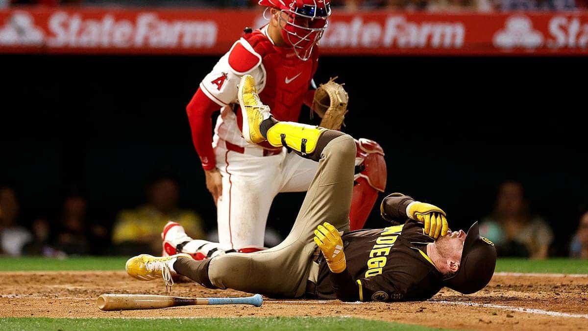 San Diego Padres' Jake Cronenworth reacting after being hit by a pitch during a baseball game