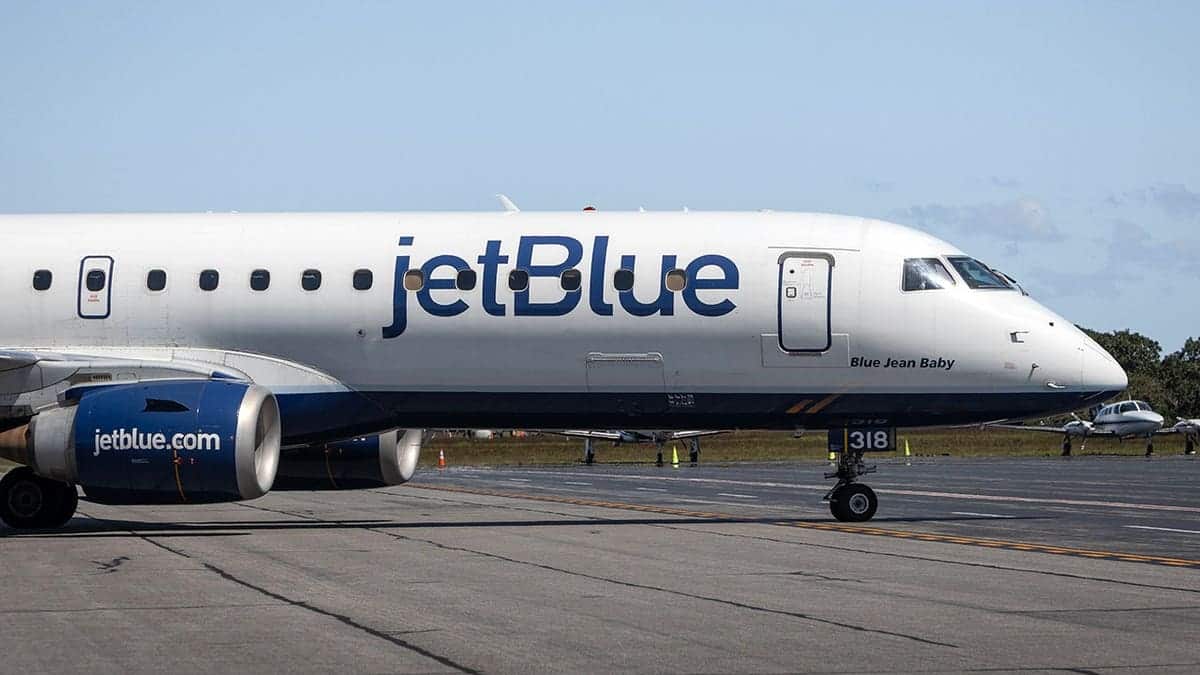 JetBlue airplane on runway under clear blue sky