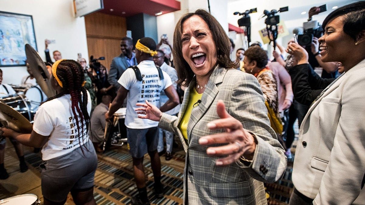 Kamala Harris pictured alongside a marching band