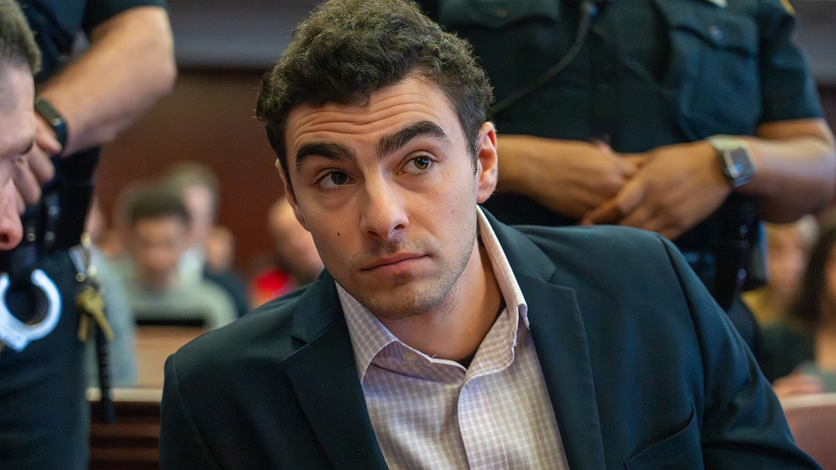 Luigi Mangione standing in a courtroom during a hearing