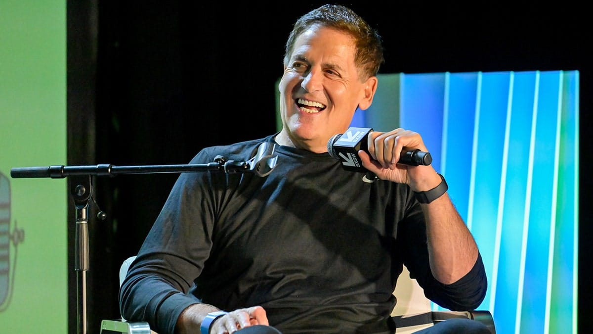 Mark Cuban holding microphone and smiling on stage at SXSW in Austin