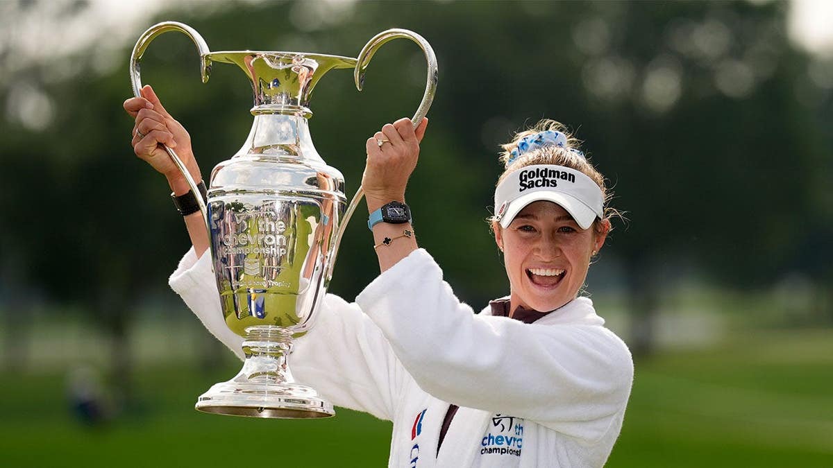 Nelly Korda hoisting the Chevron trophy