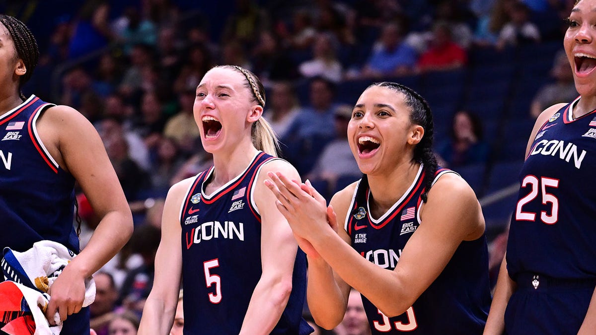 Paige Bueckers and Azzi Fudd reacting on the bench during a basketball game