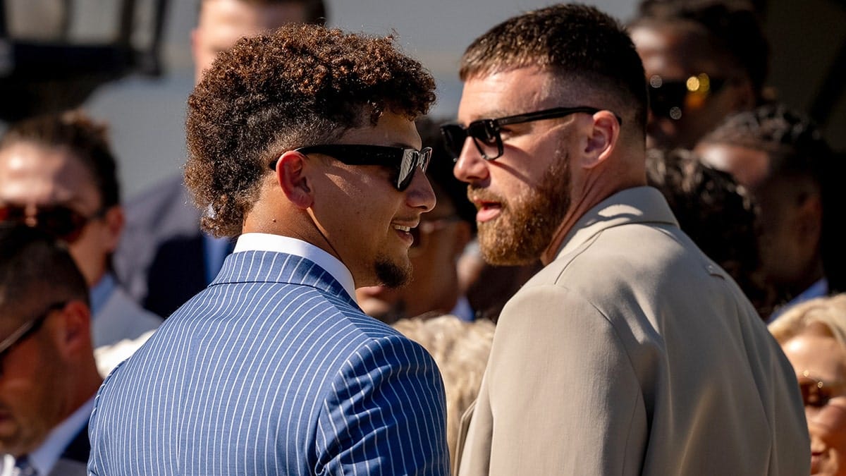 Patrick Mahomes and Travis Kelce wearing suits and sunglasses.