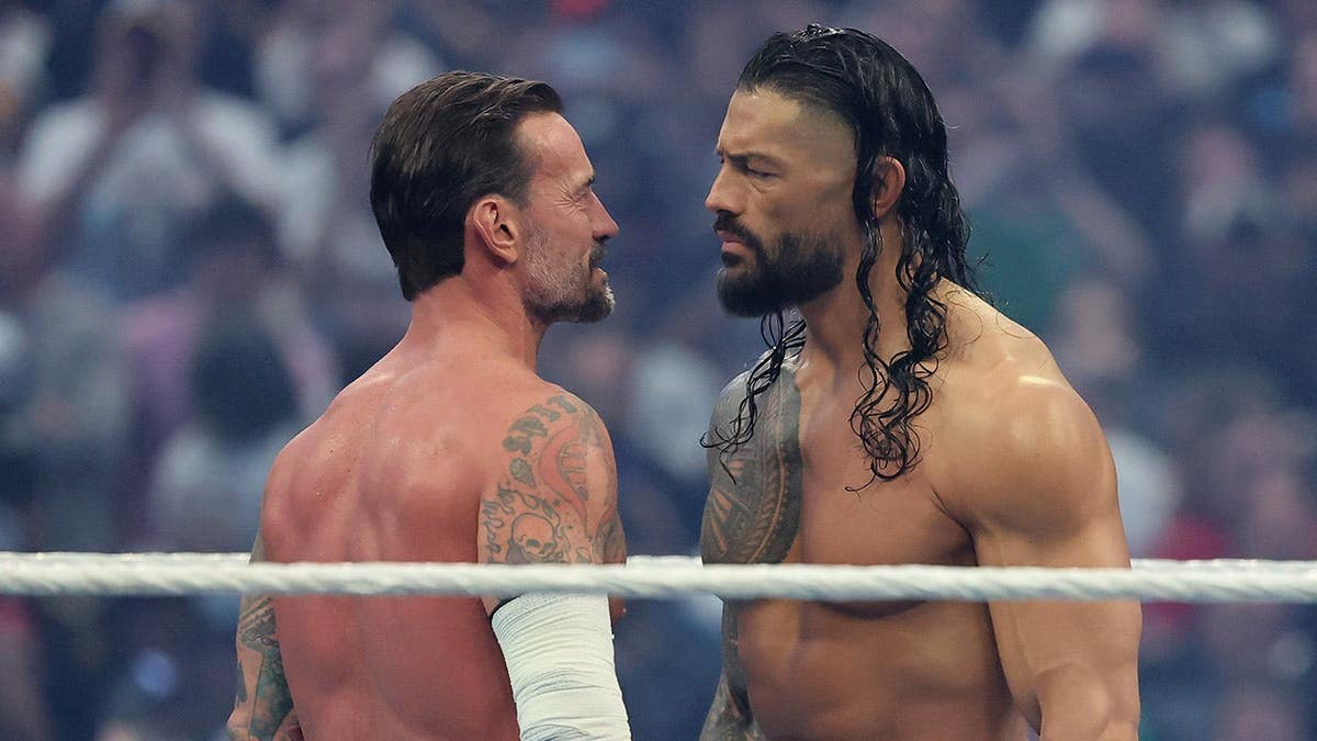 CM Punk faces off against Roman Reigns in a wrestling ring at Allegiant Stadium