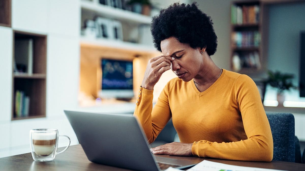 Woman holding her face looking at computer screen