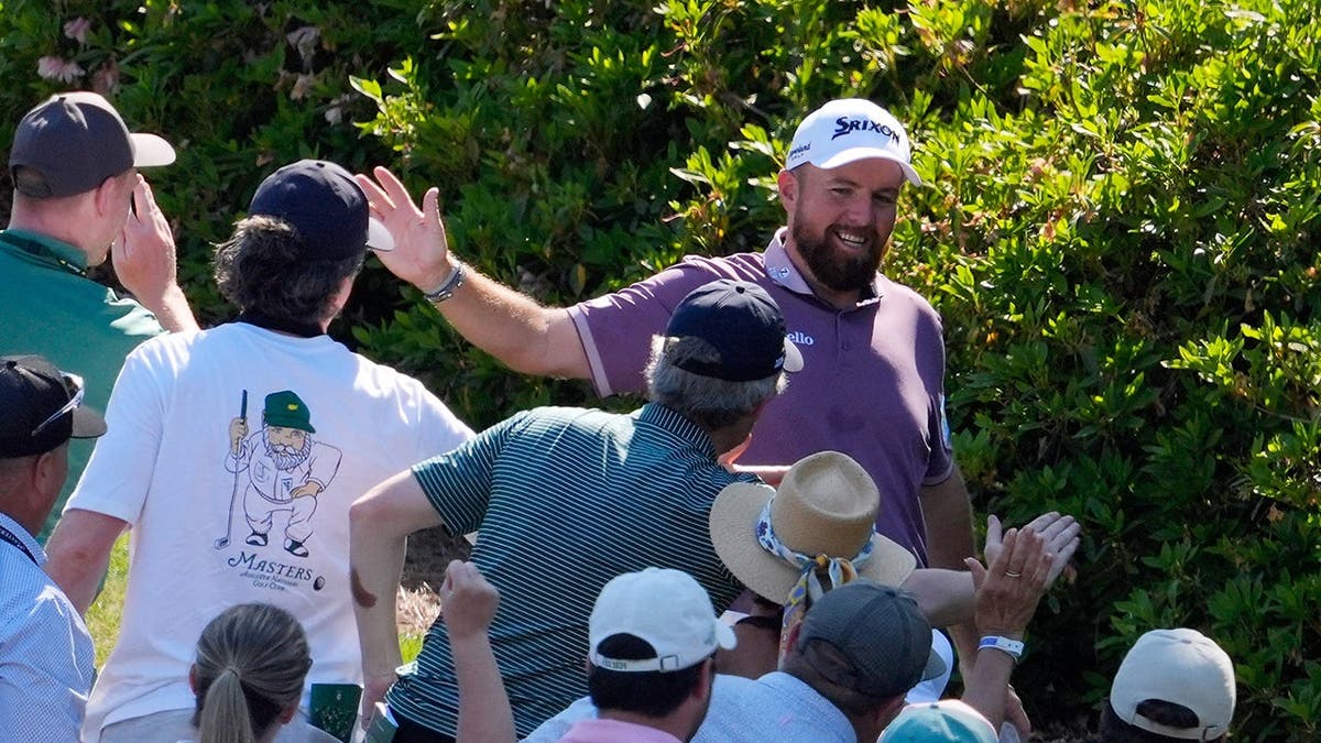 Shane Lowry high fiving patrons after hitting a hole-in-one at Augusta National Golf Club