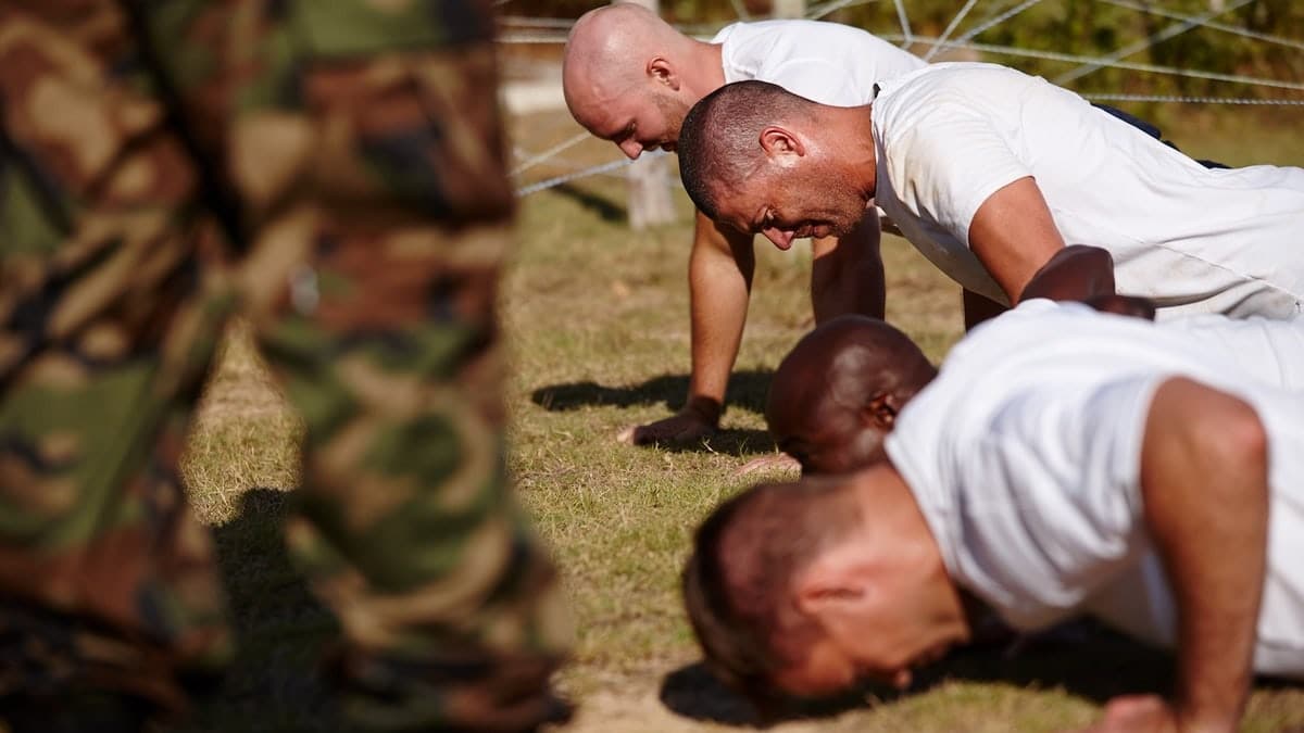 A group of men doing push-ups at a military bootcamp