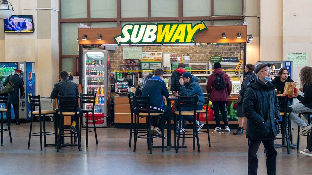 People sitting at tables inside a Subway restaurant in Saint Petersburg Russia