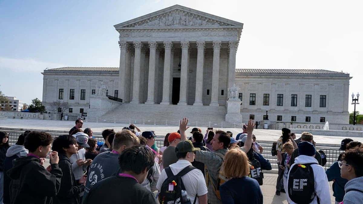 people stand in front of the Supreme Court