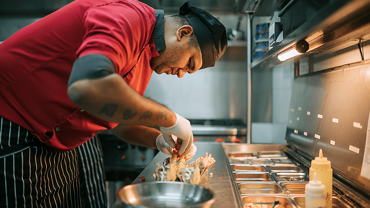 Chef makes tacos in taco truck.