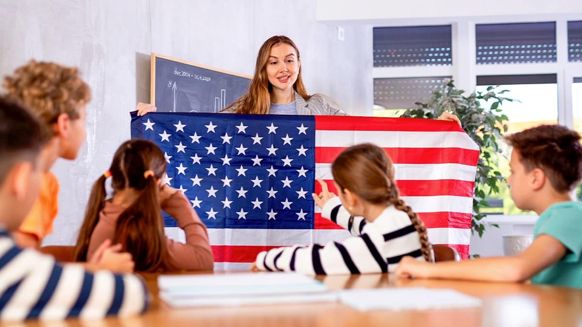 A teacher holds an American flag