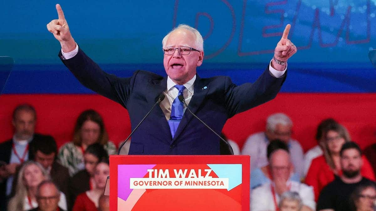 Governor Tim Walz gesturing during an event in Barcelona, Spain