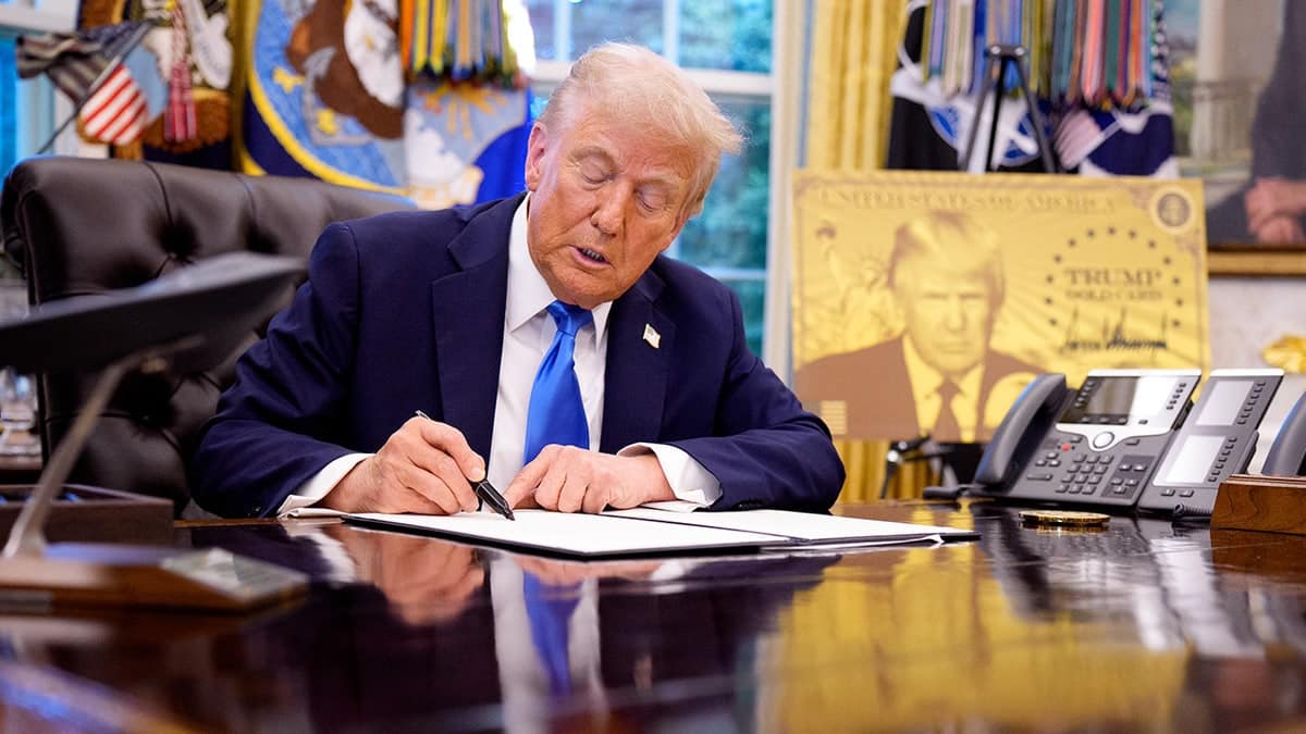 President Donald Trump sits in Oval Office and signs executive orders
