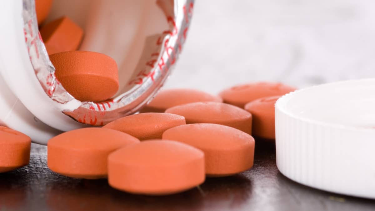 Over the counter medication on black table with bottle and cap
