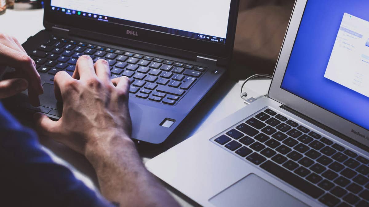 Illustration of a hacker working at a computer with code on screen